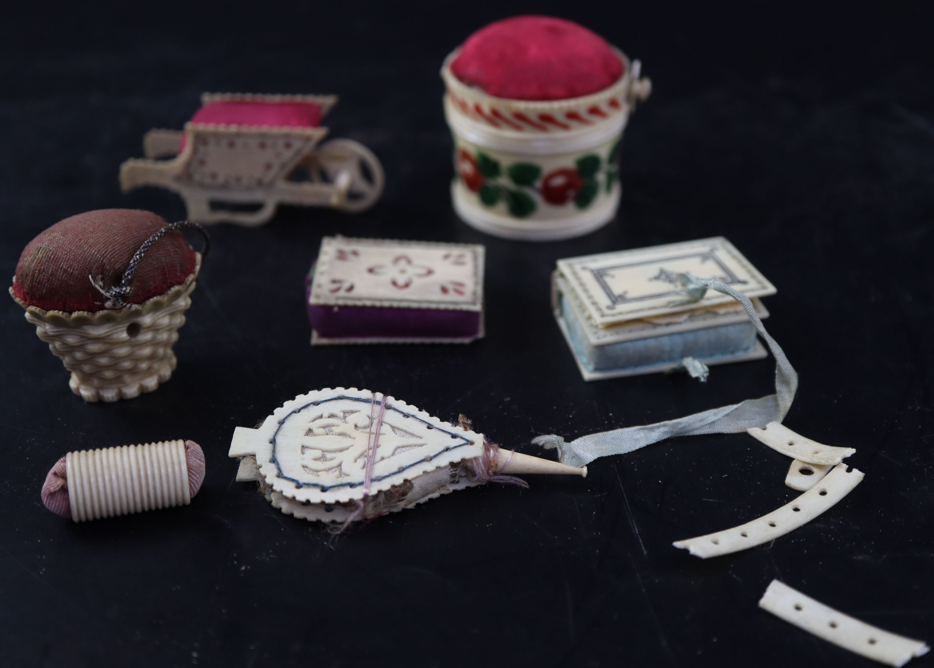 A collection of twelve 19th century carved ivory and bone pin cushions